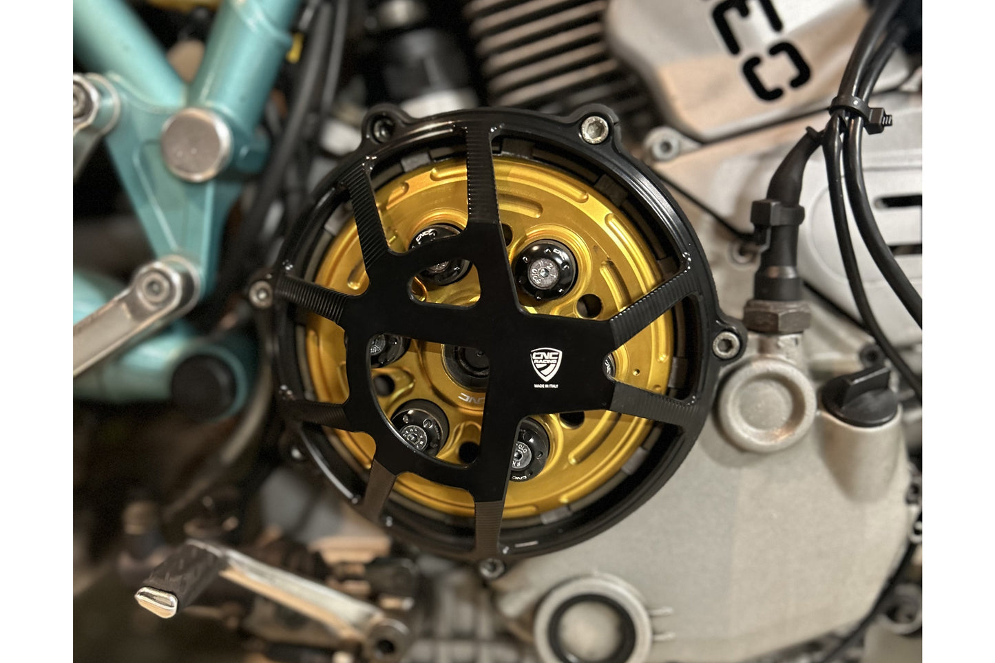 Koppelingsdeksel Traffic Ducati Supersport 750 (1998) gemonteerd in zwart met gouden drukplaat en zwarte veerschotels