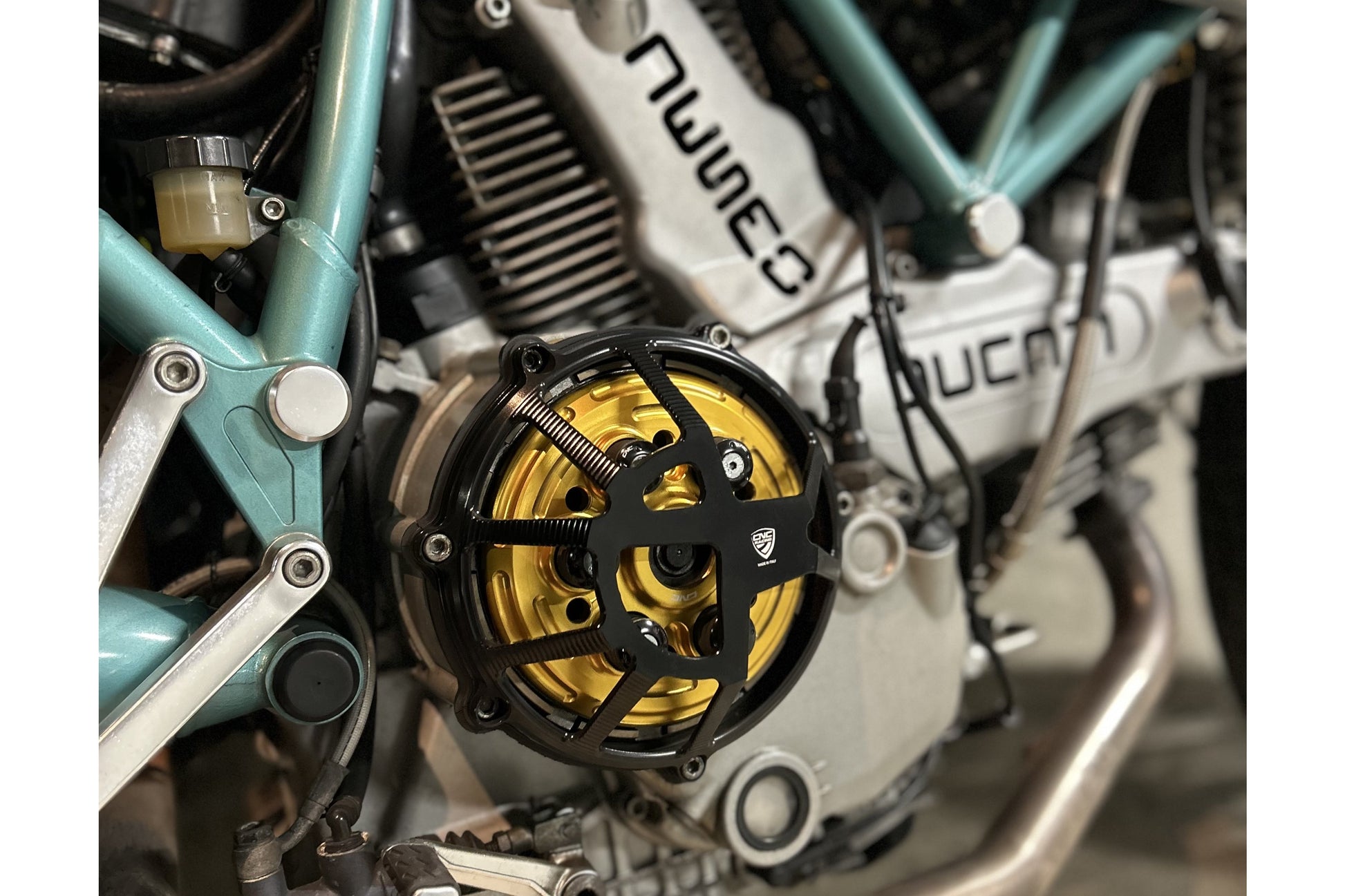 Koppelingsdeksel Traffic Ducati Monster S4RS (2006-2009) zijaanzicht in zwart met gouden drukplaat en zwarte veren plus schotels