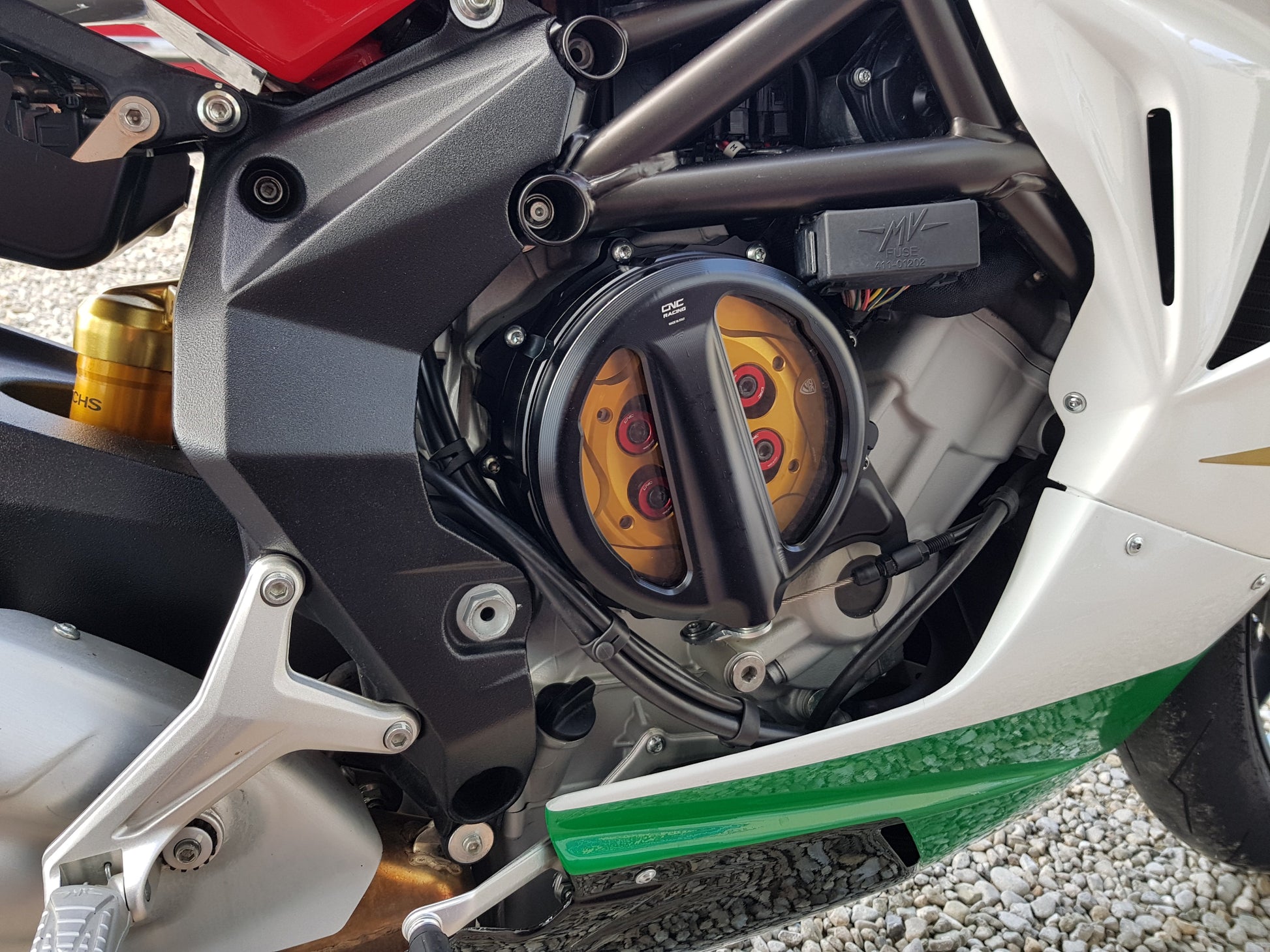 Open koppelingsdeksel met lexaan venster MV Agusta Rivale 800 (2013-2017) zwart koppelingsdeksel met gouden drukplaat en rode veerschotels