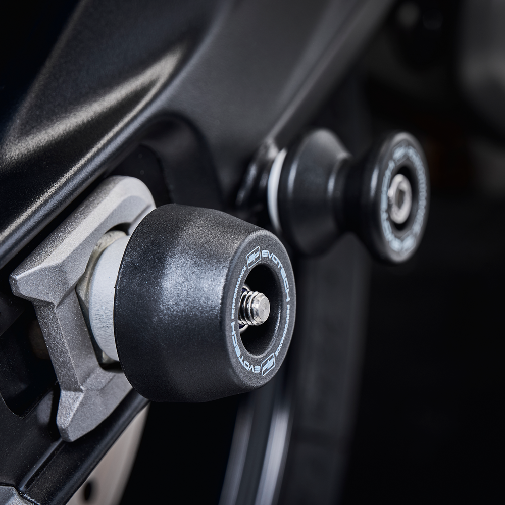 
                  
                    The rear wheel of the Tiger Sport 660 Trident with the EP Spindle Bobbins Kit’s nylon bobbin fitted, protecting the swingarm and fitted near EP Paddock Stand Bobbins.
                  
                