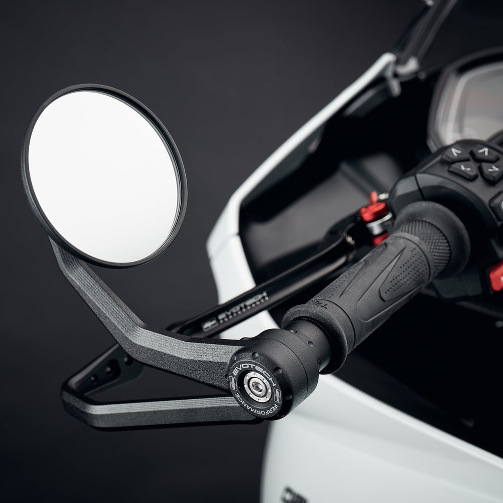 
                  
                    Evotech Bar End Mirrors / Brake and Clutch Protector Kit for the Triumph Daytona 660 attached to the handlebar ends of the motorcycle. EP's circular mirrors and integrated lever protector are installed using a bespoke fitting design.
                  
                