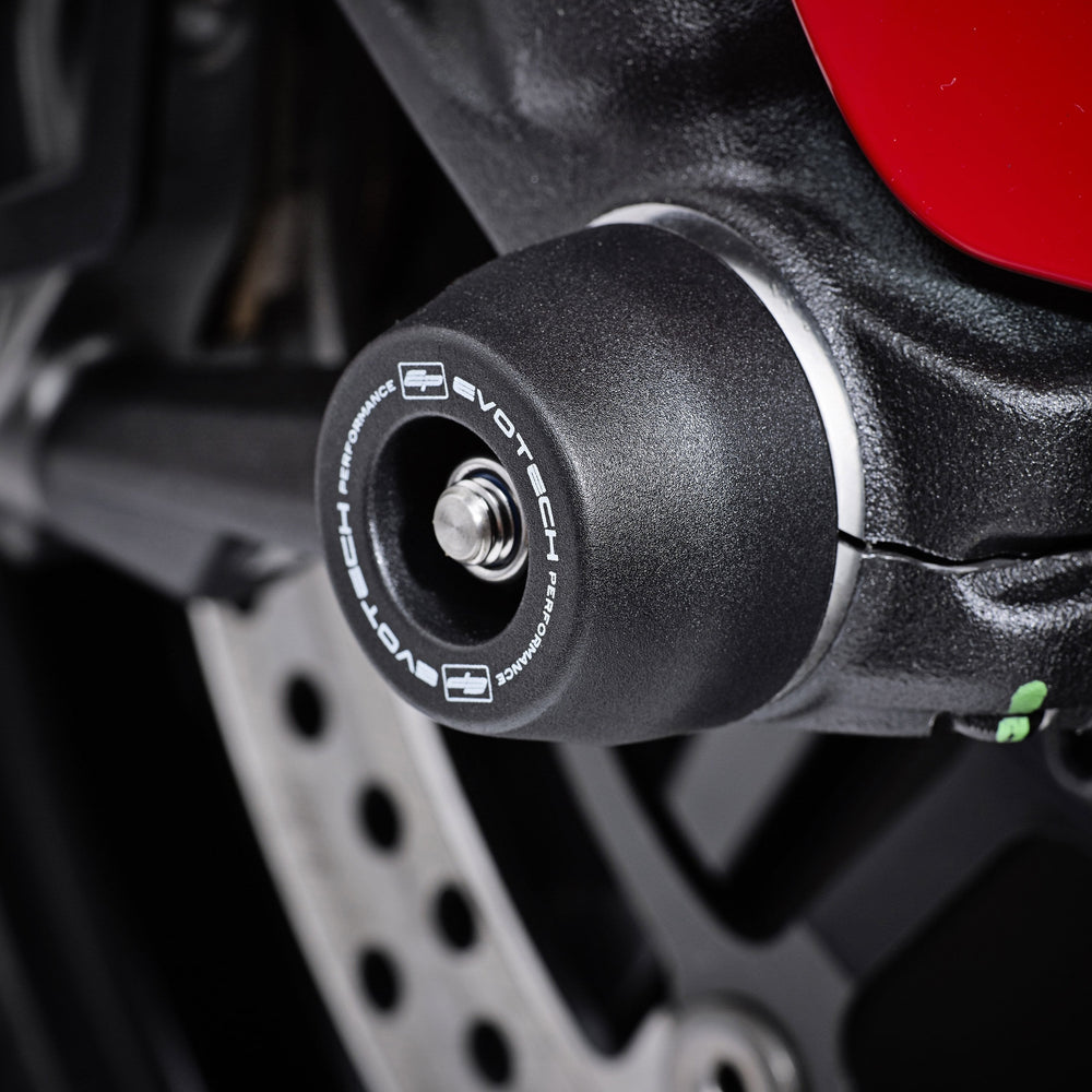 The front wheel of the Ducati Scrambler Nightshift featuring EP Front Spindle Bobbins crash protection, one half of the EP Spindle Bobbins Paddock Kit. 