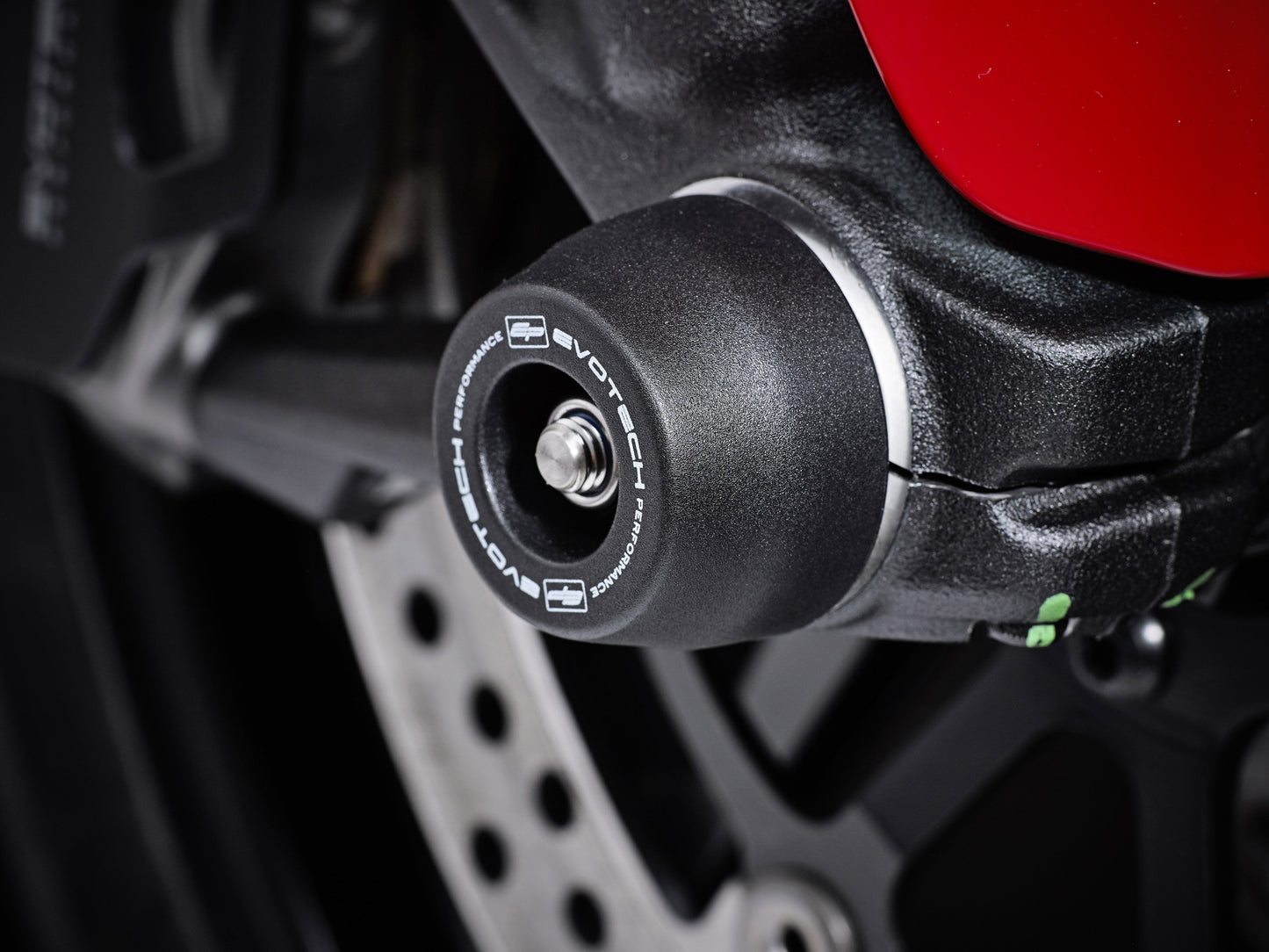 The front wheel of the Ducati Scrambler Café Racer featuring EP Front Spindle Bobbins crash protection, one half of the EP Spindle Bobbins Paddock Kit. 