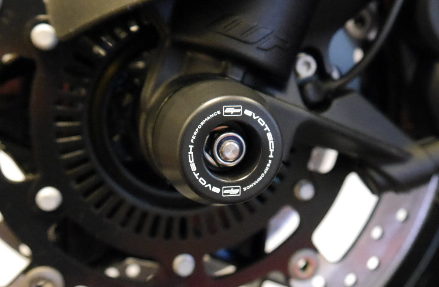 The injection-moulded nylon crash bung of EP Front Spindle Bobbins installed through the front wheel of the KTM 1190 Adventure, offering strong crash protection to the front forks and brake calipers.