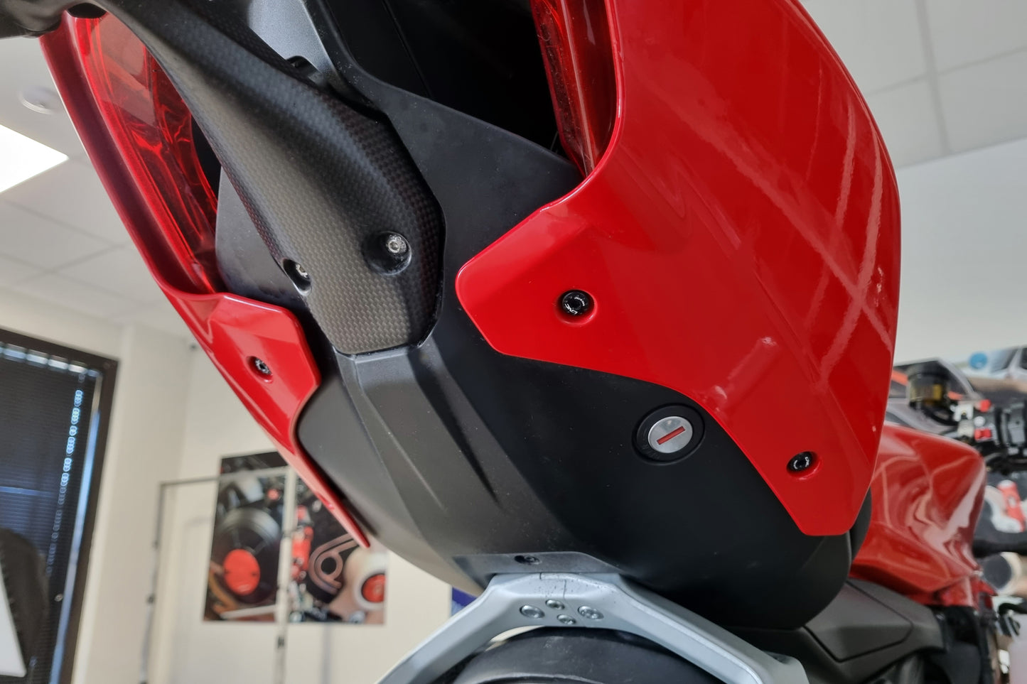 Zwarte CNC Racing undertail bouten gemonteerd op de Ducati Streetfighter, zichtbaar op het achterste zijpaneel.