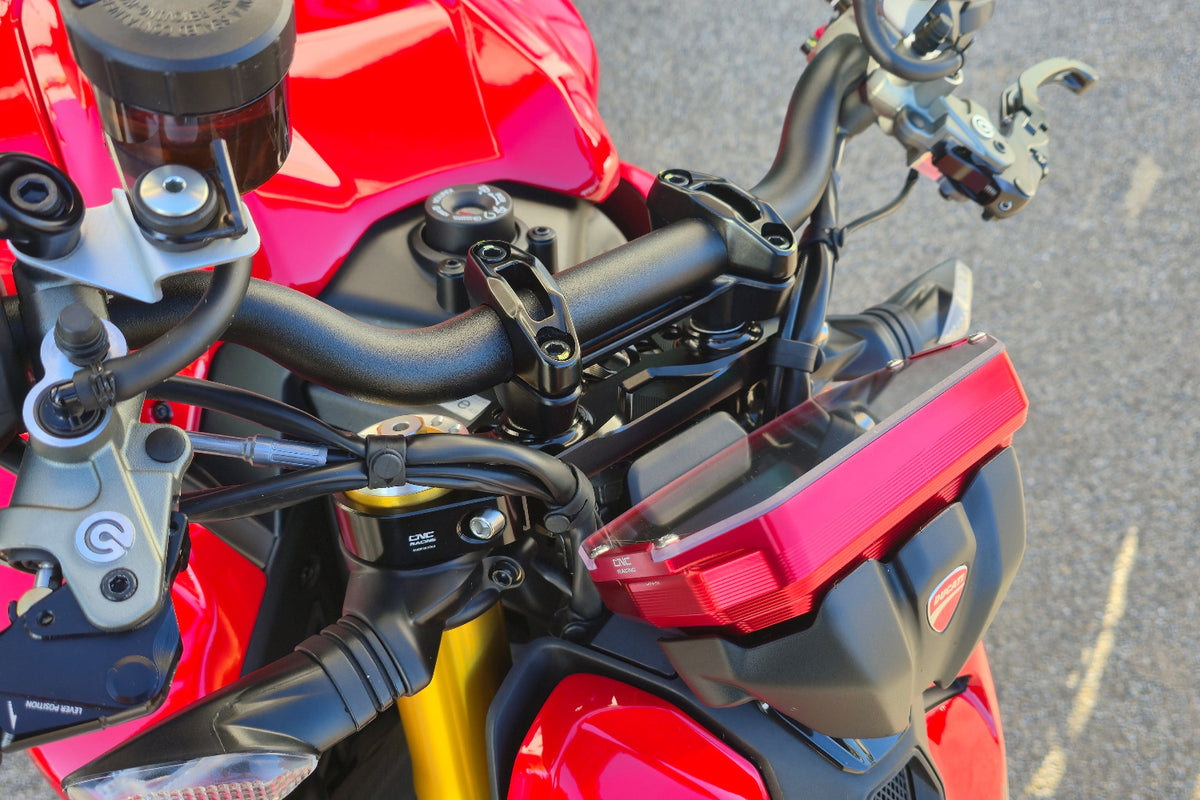 Rode CNC Racing dashboardbeschermer naast het stuur van een Ducati